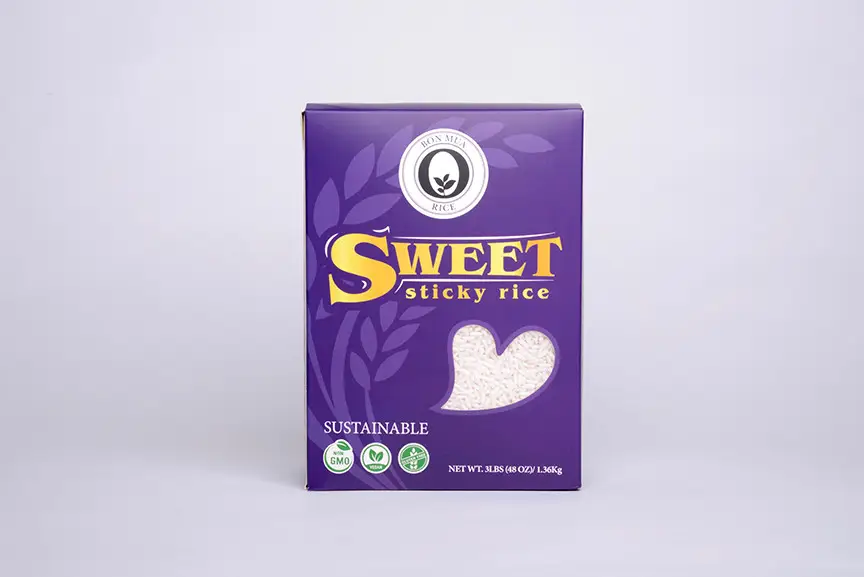 A purple Bon Mua Sweet Sticky Rice box with gold lettering and sticky-rice grains shown in a heart-shaped window, on a pale background.